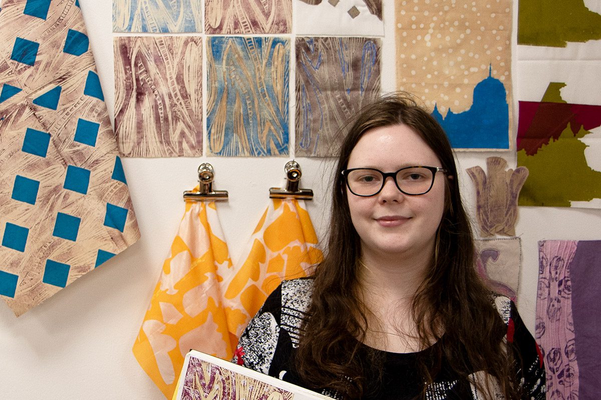 Kaitlyn Nicol next to textiles work